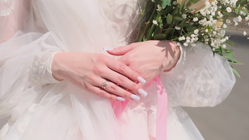 A young bride with a wedding bouquet in her hands