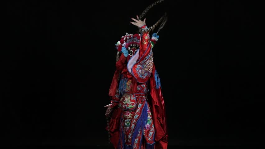 Sichuan Opera mask changing performance, dramatic traditional Chinese art on black background.