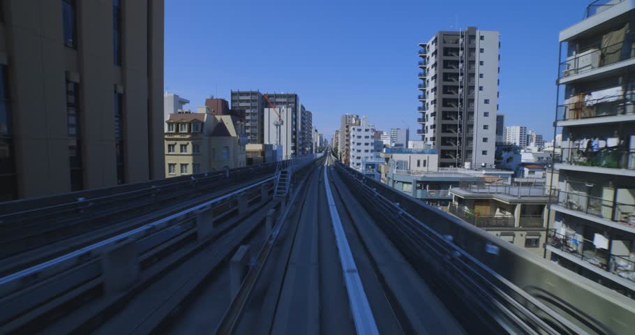 A point of view of a moving backward urban monorail at the downtown in Tokyo