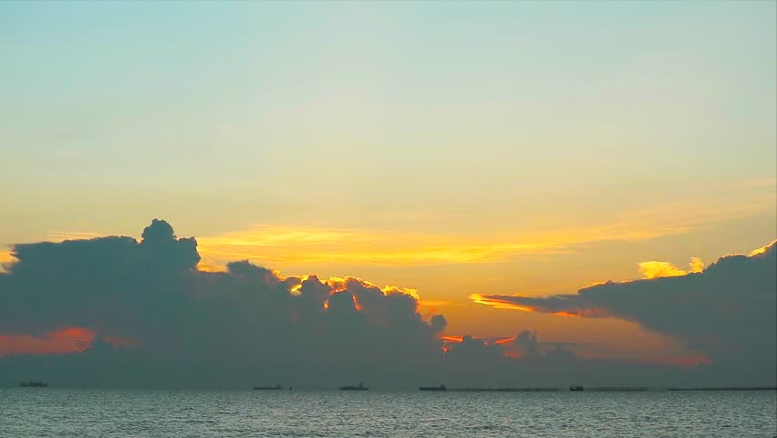 Serene Sunset Over Calm Waters with Majestic Cloud Formation