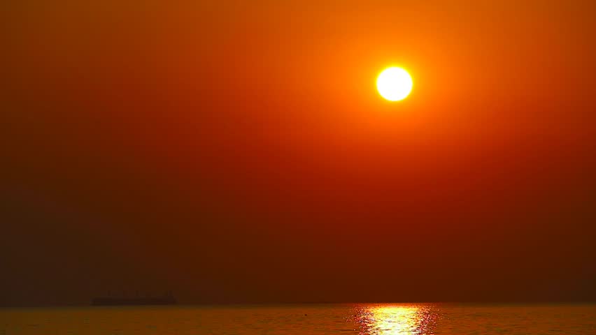 Serene Sunset Over Water with Vibrant Hues of Orange and Red