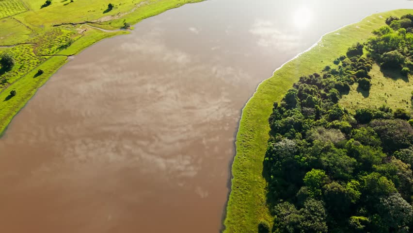 Scenic aerial footage of a muddy river winding through the verdant landscape of the colombian plains