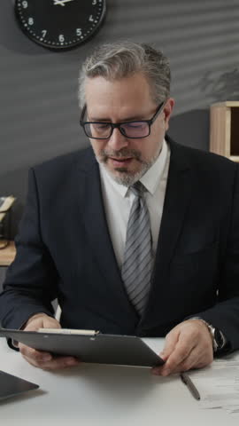 Vertical shot of mature HR manager dressed in suit extending hand and smiling at camera intending to shake hands with job applicant after interview