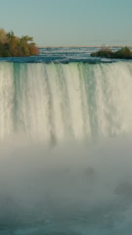 Niagara Falls dramatic waterfall edge with powerful cascade and mist rising from gorge, iconic natural landmark on USA Canada border.