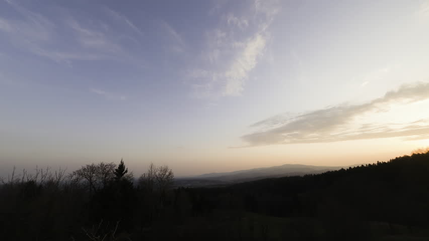 Rolling hills landscape at sunset with colorful twilight sky in rural countryside, Austria