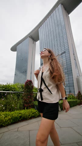 Woman walking in Singapore cityscape at Marina Bay Sands. Travel and tourism in Asia beautiful modern architecture, cityscapes.
