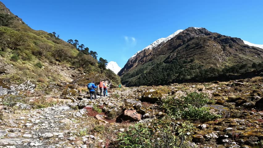 Kothe - Thangnag, Nepal - October 6, 2025: Mera Peak Trek. Climbers walk along the route among the mountain landscape. Landscape, in front of a snowy mountain peak on the sky background