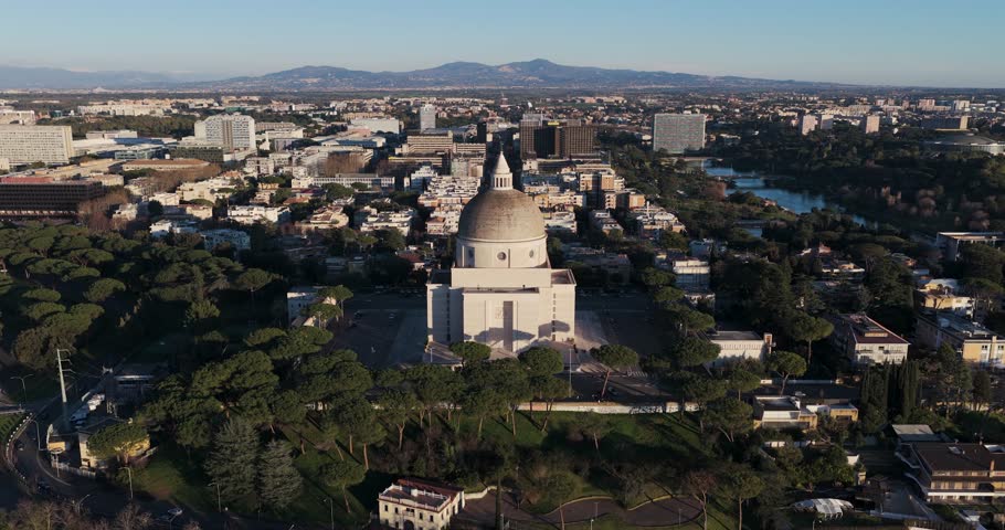 Aerial view of the Basilica of Saint Peter and Paul standing in stark contrast to the urban sprawl and the distant mountains, Rome, Lazio, Italy.