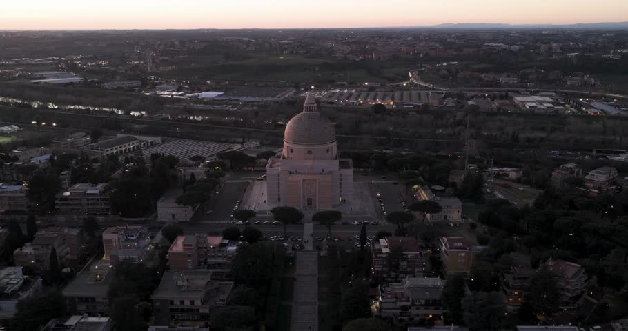 Aerial view of the Basilica of Saint Peter and Paul, a place of serene architectural beauty amid a sprawling cityscape at dusk, Rome, Lazio, Italy.