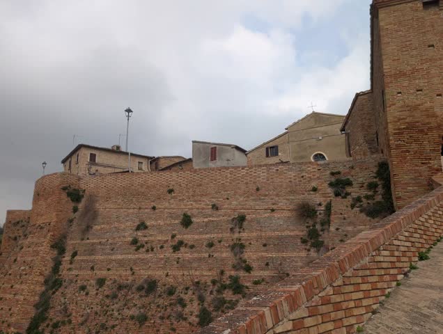 Fortified brick walls with historic buildings, medieval Italian architecture