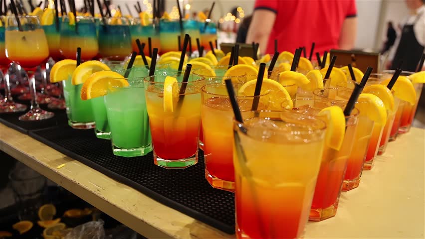 Colorful cocktails on a bar counter lined up ready to be served at a party, mixing vibrant ingredients to create a refreshing drink that adds energy, fun, and great vibes to the celebration