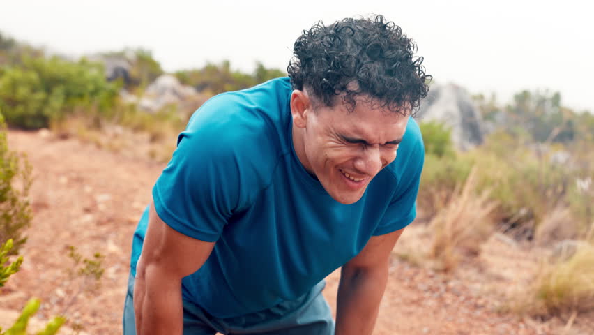 Tired, athlete and man in nature, sweating and practice for marathon, wellness and exercise routine. Outdoor, runner and person with fatigue, running and workout for fitness, breathing and exhausted