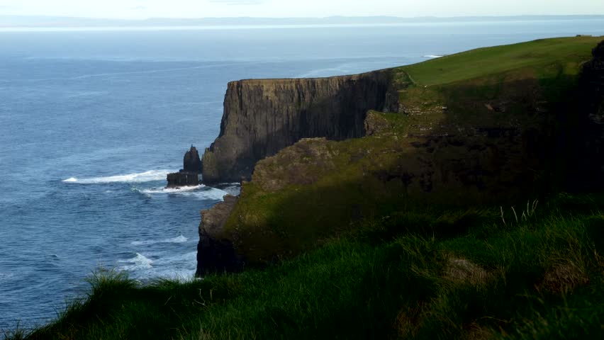 Waves waves crash into large cliffs. Cliffs of Moher. Video 4K