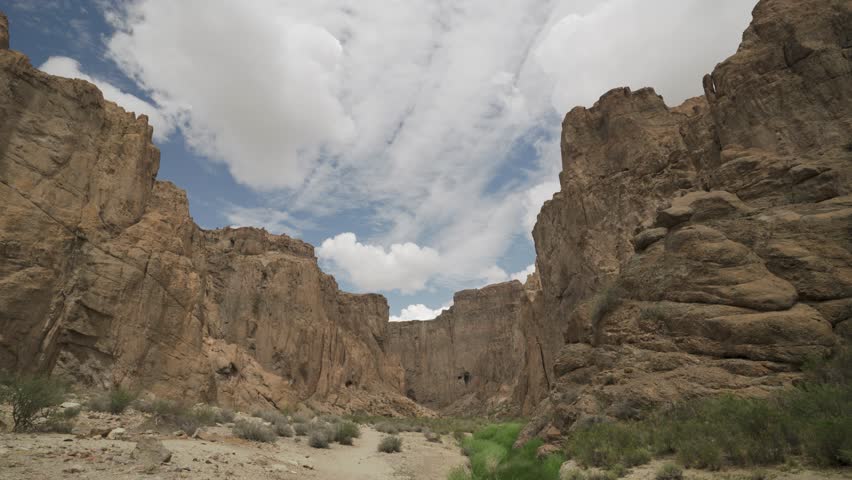 Time-lapse shot of white clouds moving fast over epic massive rocky walls in Cañadón de la Buitrera, Chubut, Patagonia, Argentina