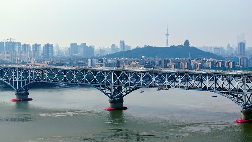 Nanjing Yangtze River Bridge crossing the Yangtze River with city skyline and TV tower in Nanjing, China.