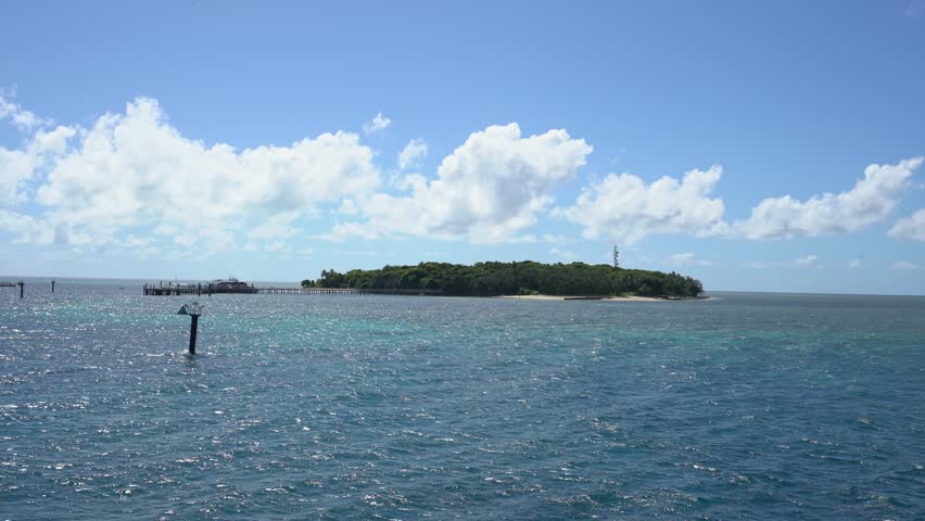 Scenic view of green island from a boat on a sunny day in the great barrier reef, australia