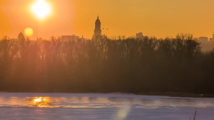 Beautiful sunset view of Kyiv in winter with frozen Dnipro River
