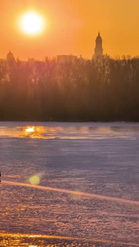 Beautiful sunset view of Kyiv in winter with frozen Dnipro River