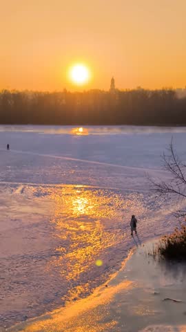 Beautiful sunset view of Kyiv in winter with frozen Dnipro River