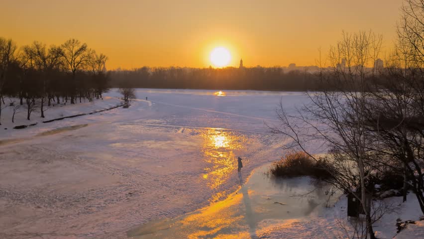 Beautiful sunset view of Kyiv in winter with frozen Dnipro River