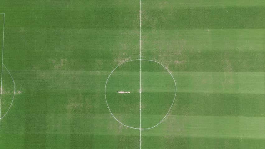 A cinematic 4K aerial drone video filmed at Estadio Municipal de Chapin in Jerez de la Frontera Cadiz Andalusia Spain. The drone ascends from outside the stadium revealing the football field and the