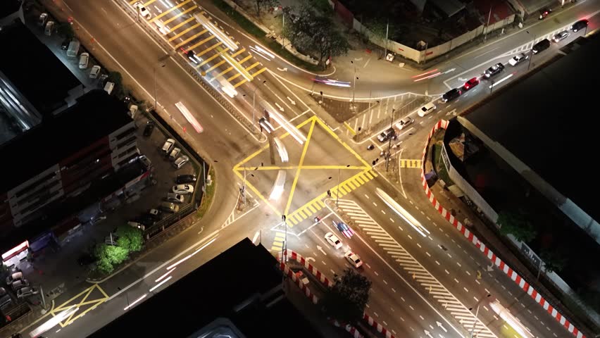 Aerial night view of light trails at a George Town road intersection in Penang, Malaysia.