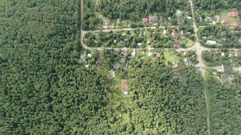 Drone Pitching above Wooded Settlement