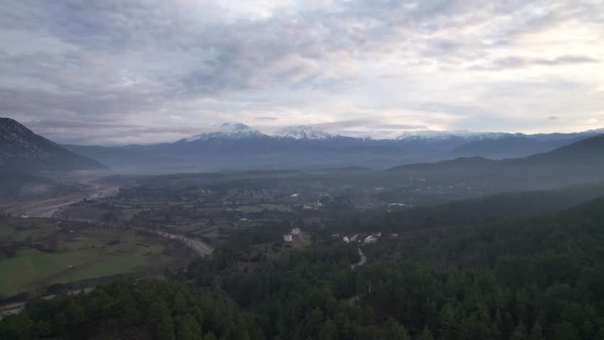 A panoramic view capturing the harmony of rural life, featuring the green agricultural fields of Çaltepe village alongside the Köprüçay river and the historic St Paul Trail in Manavgat, Türkiye