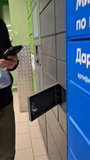 Man places white parcel into secure locker at postamat station. Simple process of shipping packages via automated terminals. Efficient logistics, trend of contactless shipping services for e-commerce - Powered by Shutterstock - Get 15% off with code: PIKWIZARD15