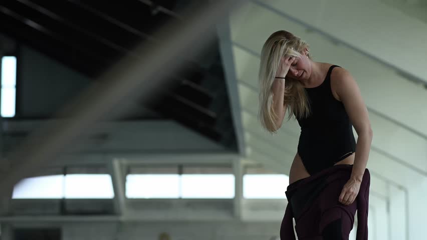 Young athletic woman preparing for freediving practice. Professional athlete dressing in a wetsuit on the edge of a swimming pool