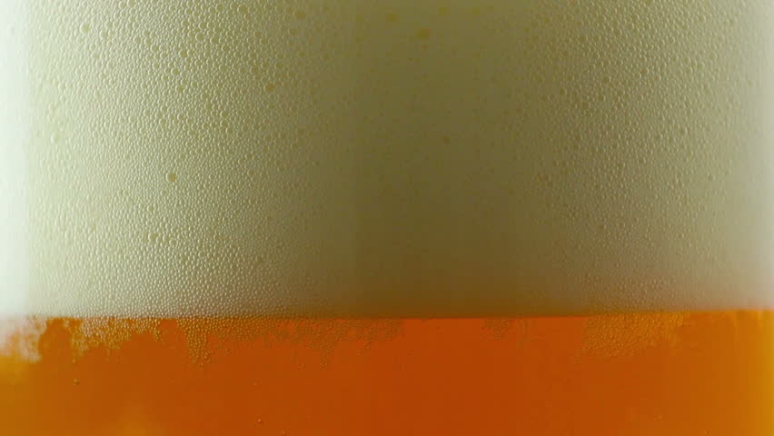 Beer being poured into translucent glass, white isolated background, detailed