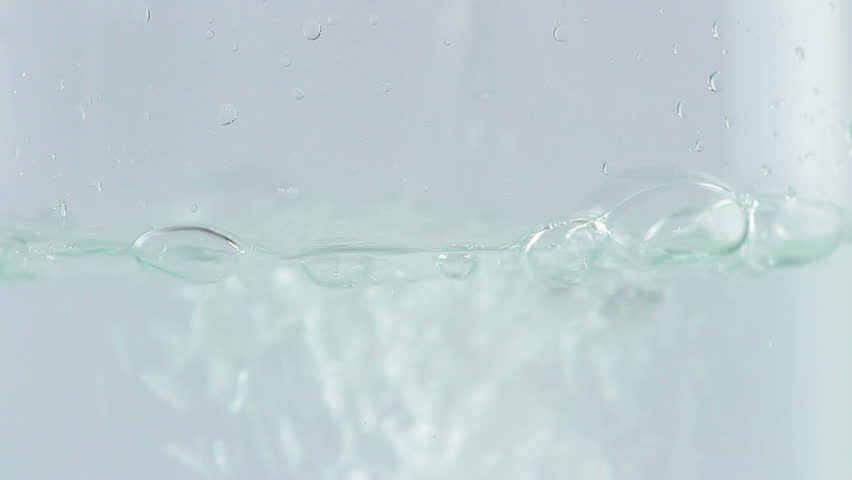 water being poured into translucent glass, white isolated background, detailed