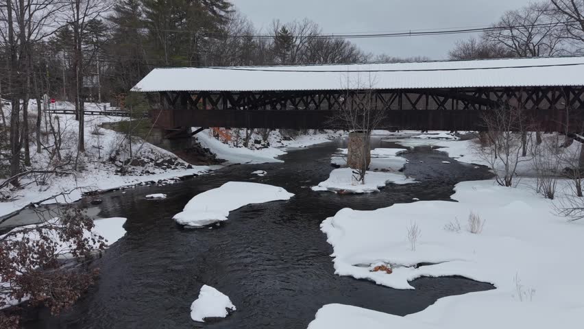 Winter aerial view featuring the historic Rowell Covered Bridge in Hopkinton, New Hampshire