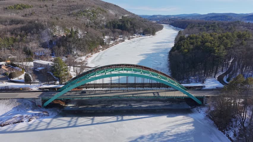 Winter aerial view featuring the United States Navy Seabees Bridge over the frozen Connecticut River Connecting Brattleboro, Vermont and West Chesterfield, New Hampshire
