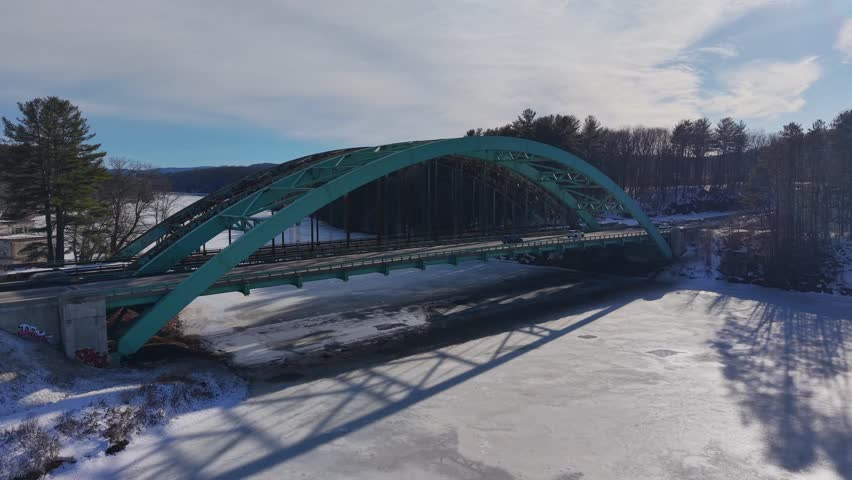 Winter aerial view featuring the United States Navy Seabees Bridge over the frozen Connecticut River Connecting Brattleboro, Vermont and West Chesterfield, New Hampshire