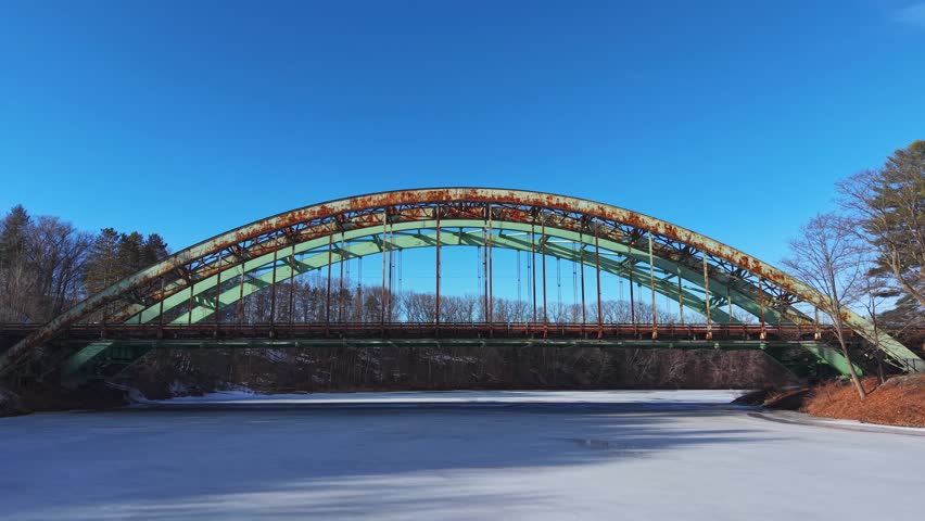 Winter aerial view featuring the United States Navy Seabees Bridge over the frozen Connecticut River Connecting Brattleboro, Vermont and West Chesterfield, New Hampshire