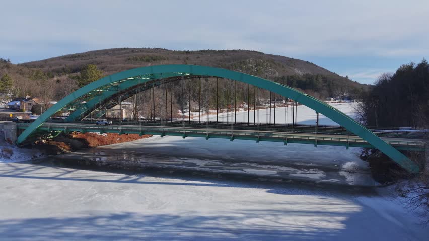 Winter aerial view featuring the United States Navy Seabees Bridge over the frozen Connecticut River Connecting Brattleboro, Vermont and West Chesterfield, New Hampshire