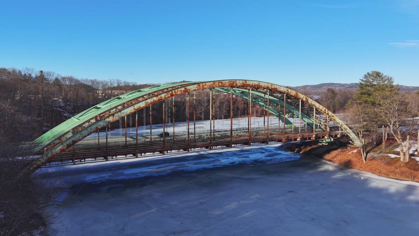 Winter aerial view featuring the United States Navy Seabees Bridge over the frozen Connecticut River Connecting Brattleboro, Vermont and West Chesterfield, New Hampshire