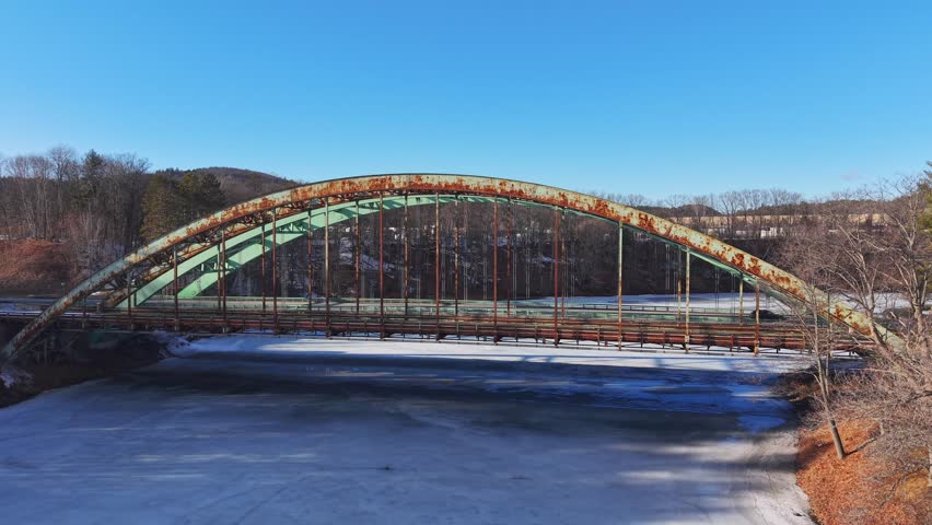 Winter aerial view featuring the United States Navy Seabees Bridge over the frozen Connecticut River Connecting Brattleboro, Vermont and West Chesterfield, New Hampshire