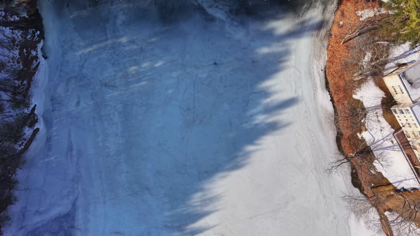 Winter aerial view featuring the United States Navy Seabees Bridge over the frozen Connecticut River Connecting Brattleboro, Vermont and West Chesterfield, New Hampshire