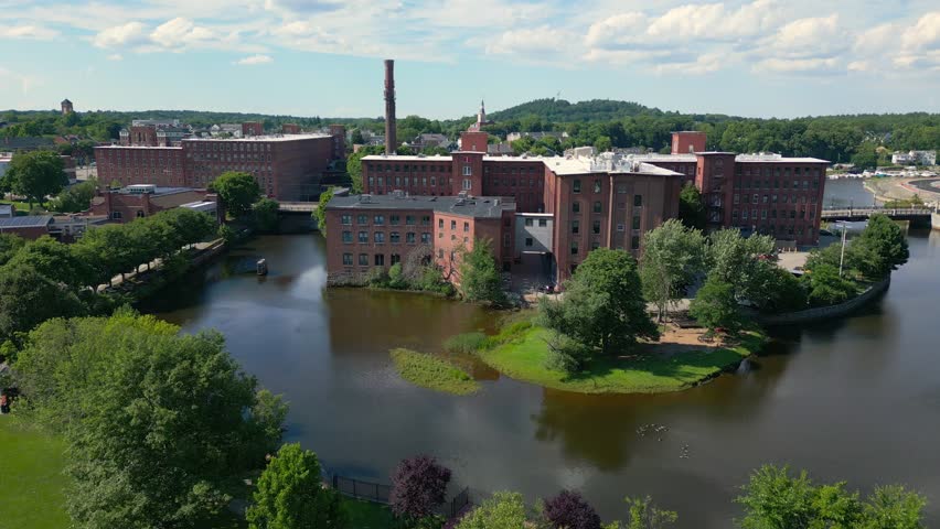 Slow rising drone shot of the historic mill in downtown Dover, NH, USA.It rveals the rest of the city on a warm, bright summer day.