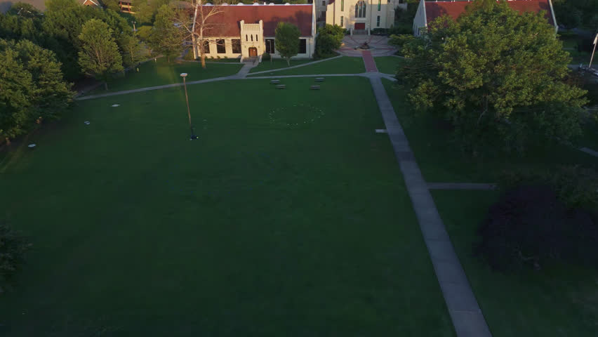 Footpath Along The Green Lawn Towards The Cathedral Of The Ozarks At John Brown University In Siloam Springs, Arkansas, USA. - aerial shot