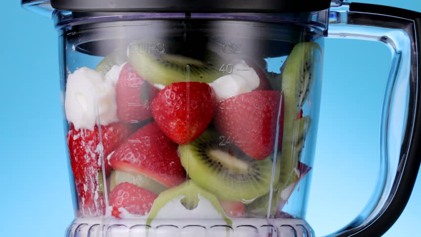 closeup up, HD video of strawberries and kiwi slices blended in a mixer to make