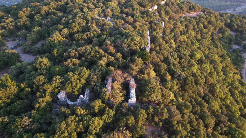 Detailed view of ancient Lycian sarcophagi, city walls, and stone ruins glowing under daylight in the ancient city of Kyaneai, Demre, Antalya