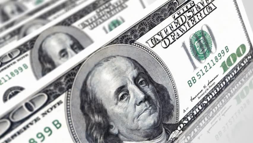 A close-up view of multiple US 100 dollar bills, featuring the portrait of Benjamin Franklin.