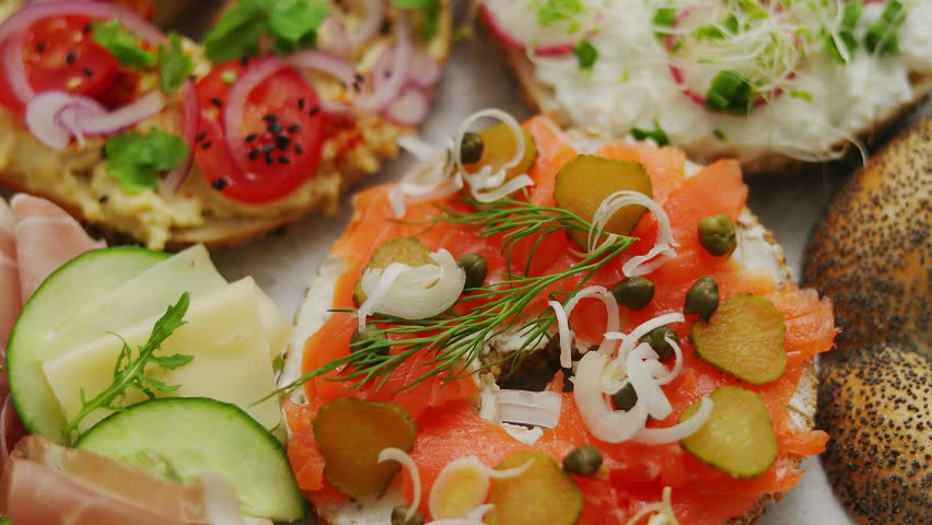 A close-up view of a vibrant spread of open-faced sandwiches and bagels, each meticulously prepared with a variety of fresh and colorful toppings.