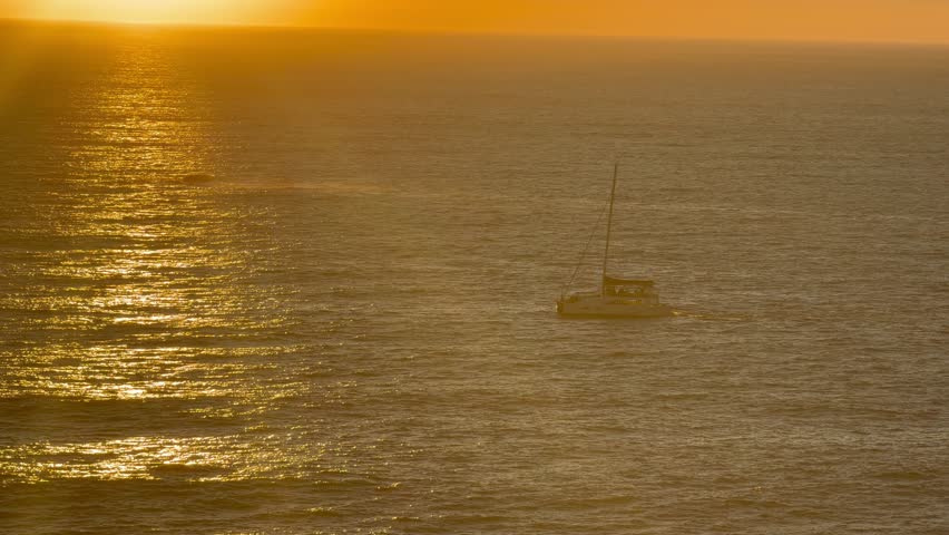 A yacht sails into the sunset over the Atlantic Ocean near Cape Town.