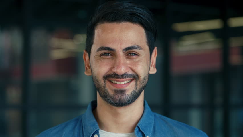 Portrait of Arab man takes picture with camera and smiles near business center closeup. Positive male journalist captures moment by photography in city district