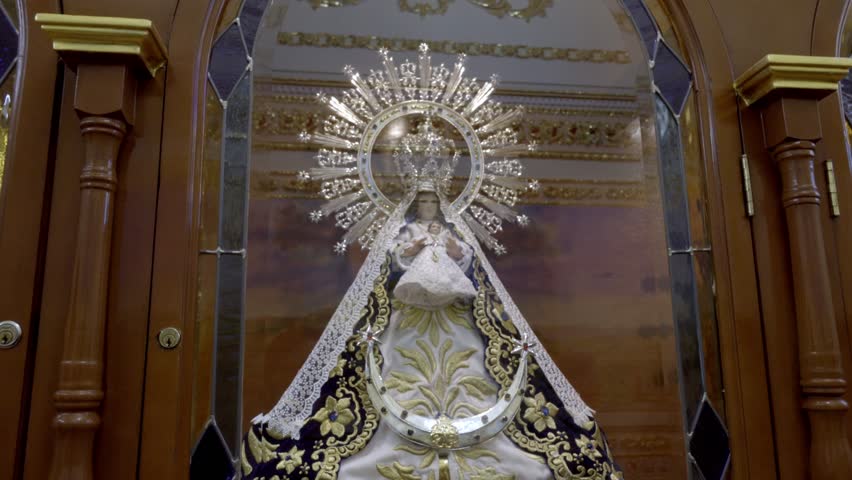 Religious statue of the Virgin Mary displayed inside a decorated Catholic church in Cholula Puebla Mexico with ornate altar architecture.