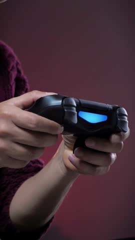 Close up of female hands holding controller of game console. Excited female playing video games, pressing buttons on game joystick. Vertical video